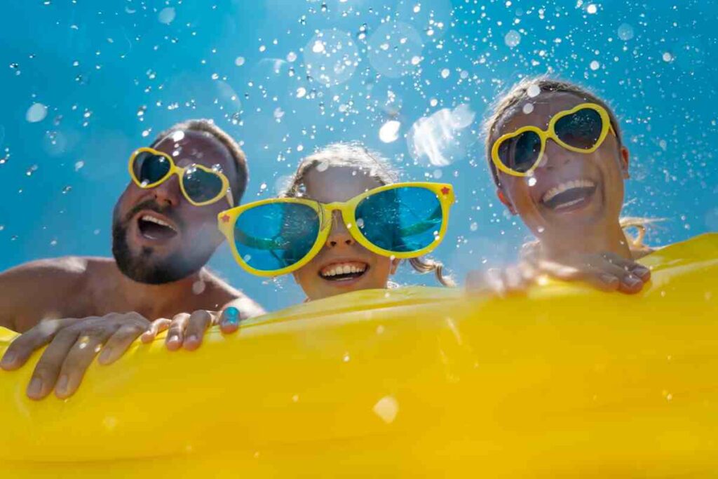 coppia con bambini si diverte in un parco acquatico nel week end estivo