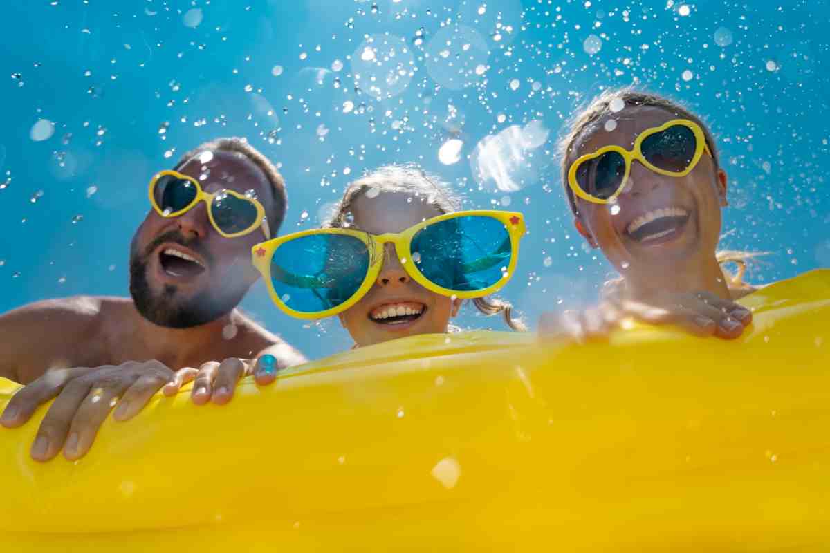 coppia con bambini si diverte in un parco acquatico nel week end estivo