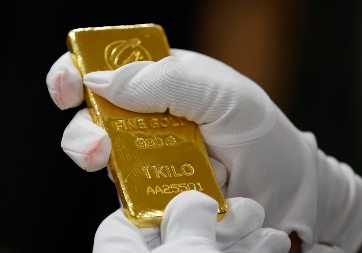 Un lingotto d'oro che sta per essere valutato e pesato