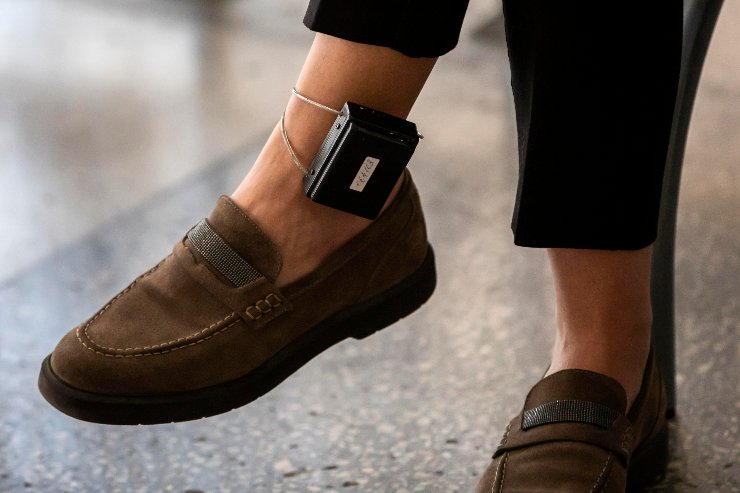 Un uomo mentre indossa un simil braccialetto elettronico