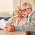Due anziani che stanno osservando un documento e sono preoccupati