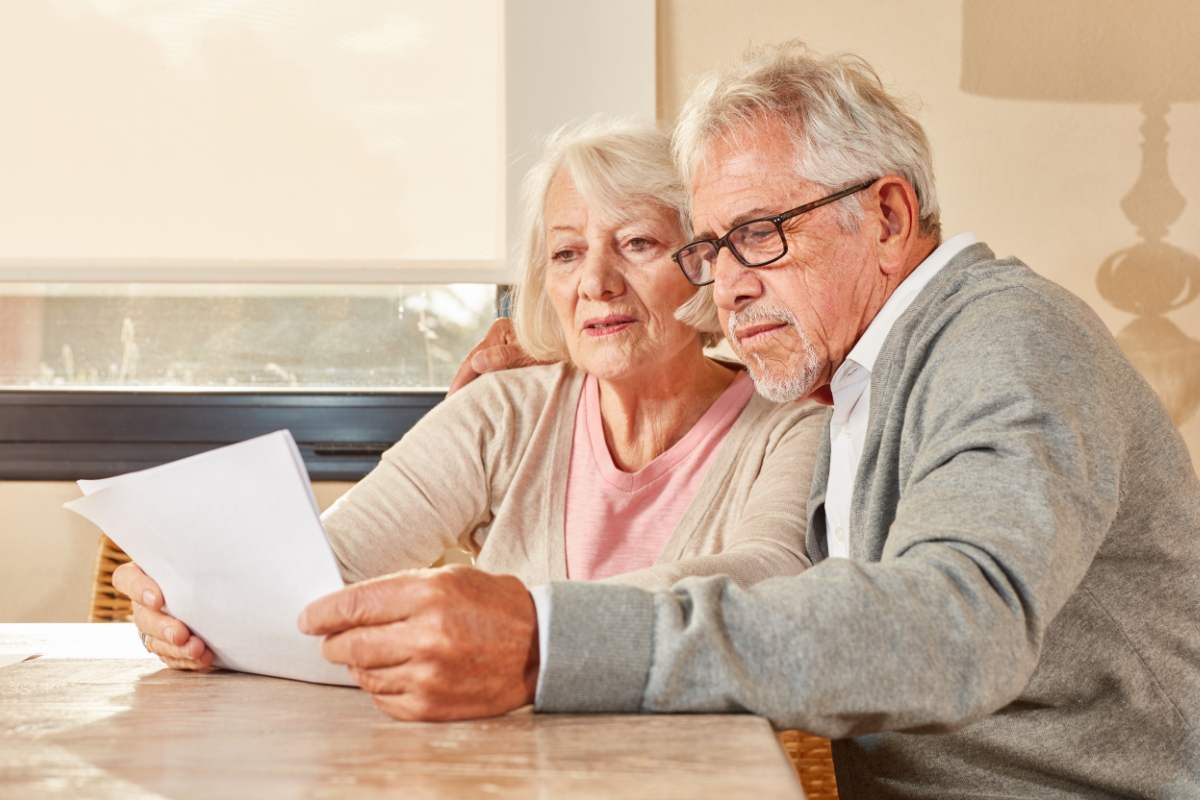 Due anziani che stanno osservando un documento e sono preoccupati