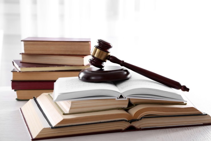 Dei libri di legge alcuni aperti altri chiusi ed un martello da giudice sopra