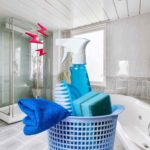 sfondo bagno e cesta con strumenti del pulito