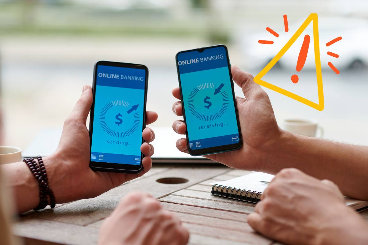 Due persone con due telefoni, uno che fa un bonifico e l'altro che lo riceve ed in alto a sinistra un segnale di pericolo