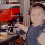 Una foto di un bambino davanti alla macchina del caffè
