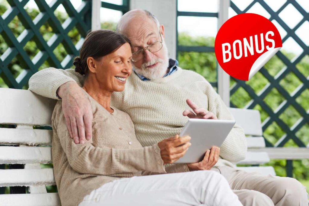 Due pensionati che vedono un tablet ed una scritta bonus in alto a destra