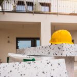 Il materiale per il cappotto termico di fronte ad una casa ed un elmetto per lavoratori