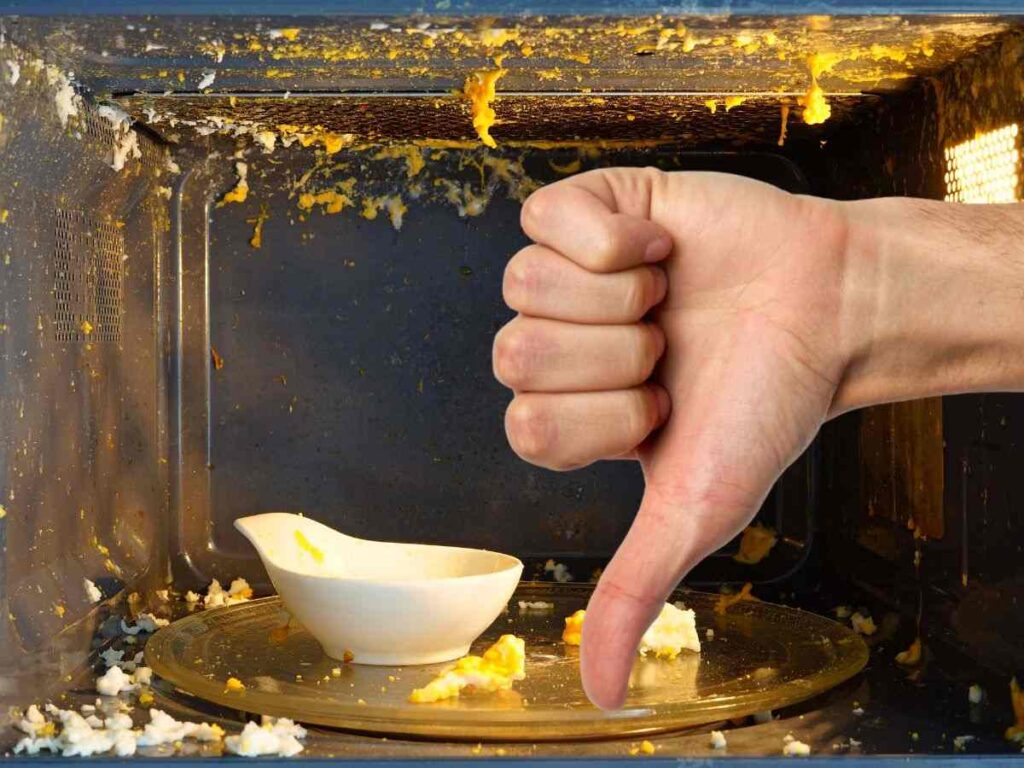 sfondo microonde con cibo scoppiato e ciotola e pollice in giù