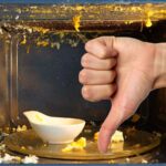 sfondo microonde con cibo scoppiato e ciotola e pollice in giù