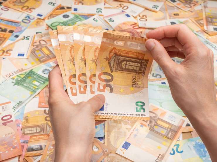 banconote euro in mano e sulla sfondo 