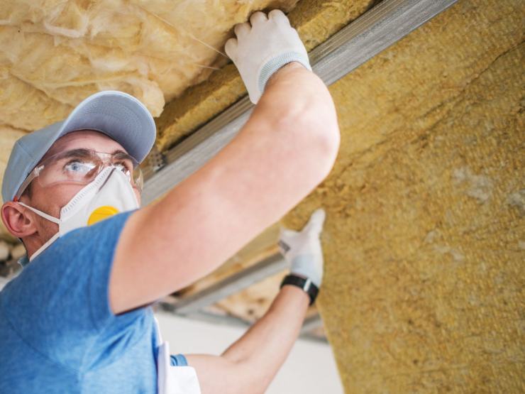 operaio installa coibentazione termica