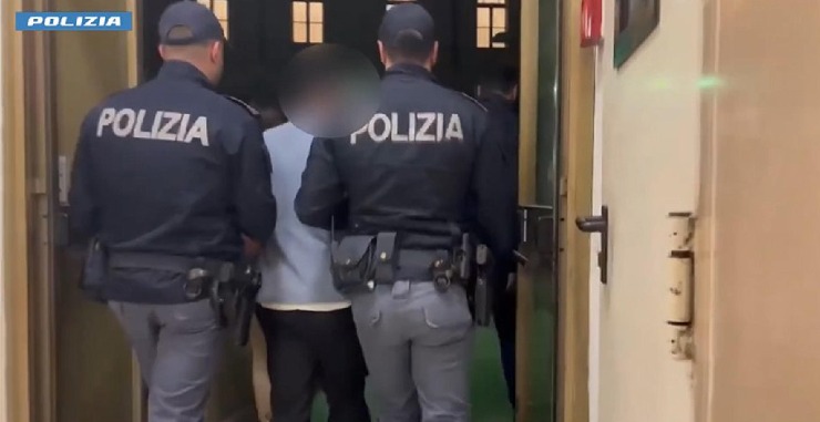 Due agenti che arrestano una persona e lo conducono in caserma