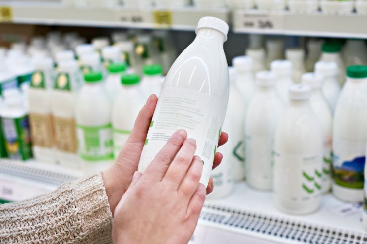 Una persona che ha in mano una bottiglia di latte