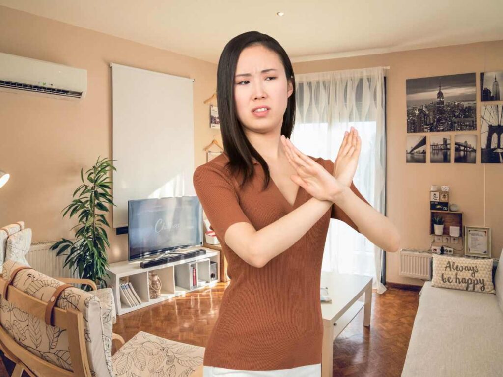 sfondo casa e donna che fa X no con le braccia