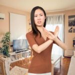 sfondo casa e donna che fa X no con le braccia