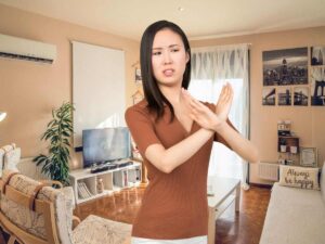 sfondo casa e donna che fa X no con le braccia