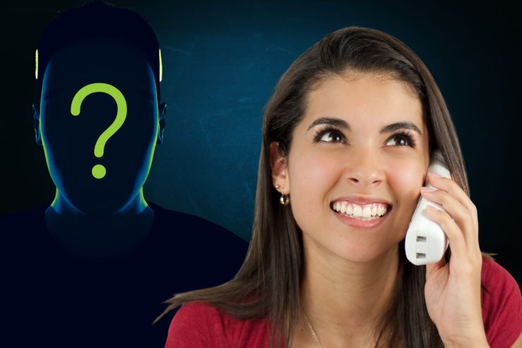 Una persona al telefono ed alle spalle una persona anonima