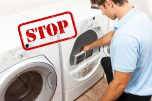 Un ragazzo che usa l'asciugatrice e una scritta stop in alto a sinistra