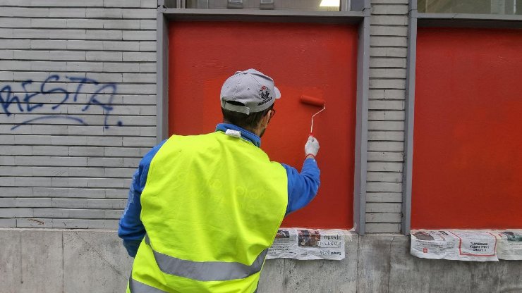 Un operaio del Comune che toglie le svastiche e le scritte contro gli ebrei