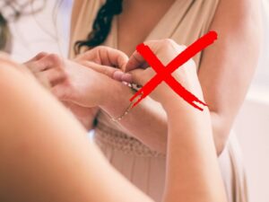 sfondo donna aiuta altra donna ad allacciare braccialetto e X rossa