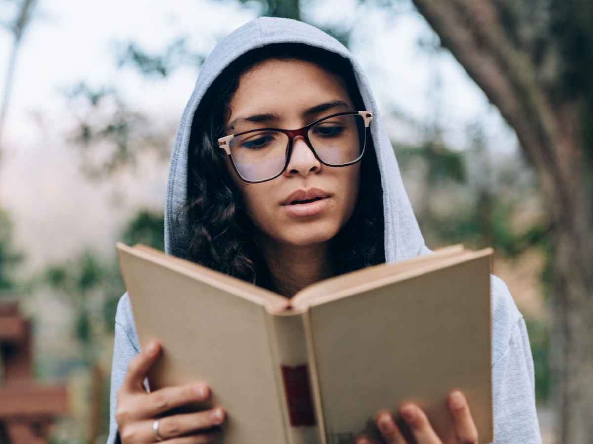 Giovane che legge un libro da sola