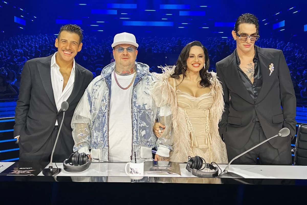 Giudici x Factor in piedi dietro bancone