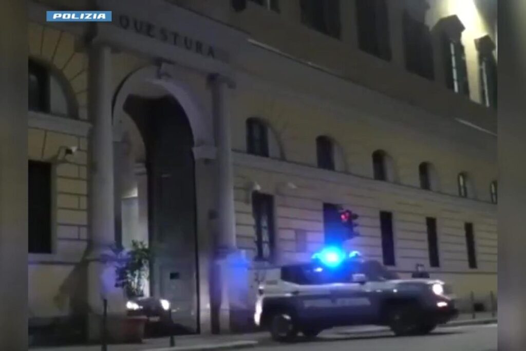 La Questura di Bergamo con una macchina della polizia che esce all'impazzata