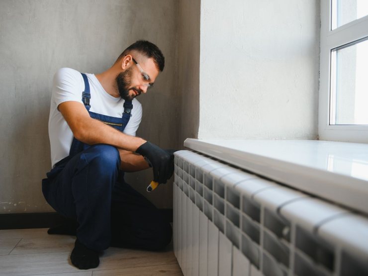 operatore fa manutenzione a termosifoni 