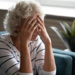 donna anziana con le mani sulla faccia