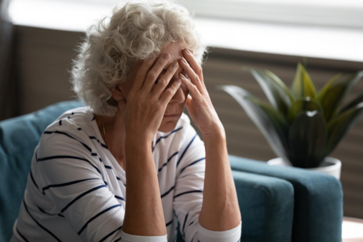 donna anziana con le mani sulla faccia