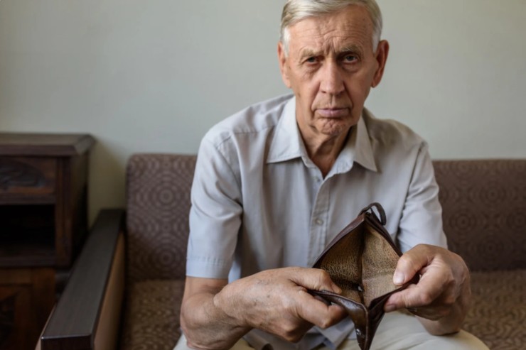 anziano con in mano un portafoglio vuoto