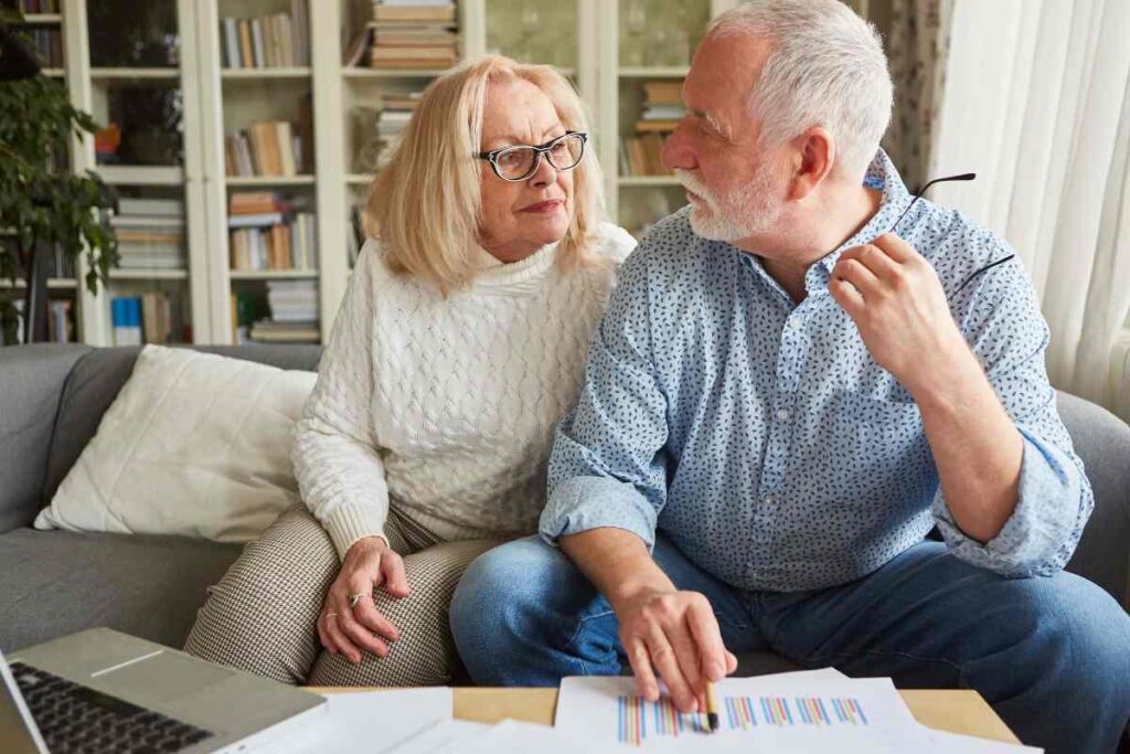 Due pensionati che si guardano preoccupati dopo aver letto dei documenti