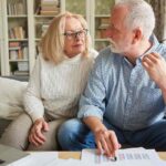 Due pensionati che si guardano preoccupati dopo aver letto dei documenti