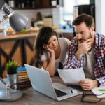 Una coppia che guarda lo schermo di un computer e sono preoccupati