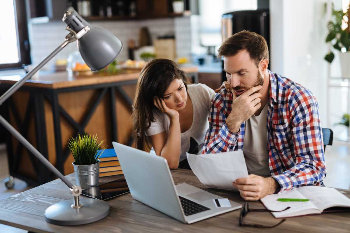 Una coppia che guarda lo schermo di un computer e sono preoccupati 