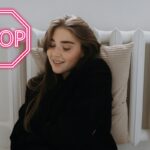 Una persona sdraiata su un termosifone ed un segnale di stop in alto a sinistra