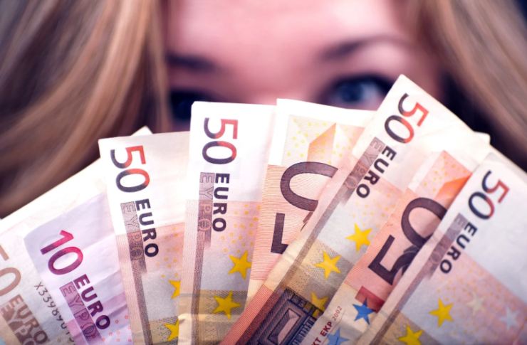 donna con tante banconote di euro davanti al viso