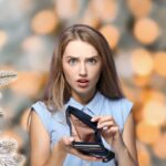 sfondo natalizio donna perplessa con il portafoglio vuoto