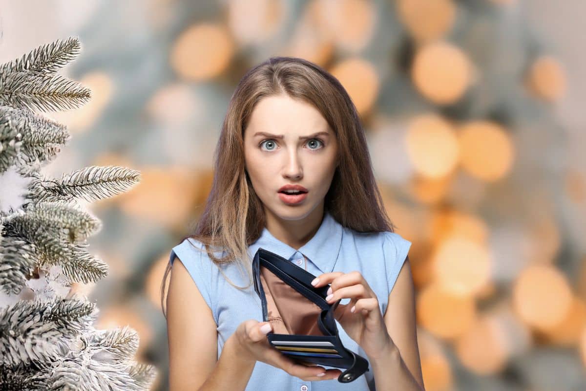 sfondo natalizio donna perplessa con il portafoglio vuoto