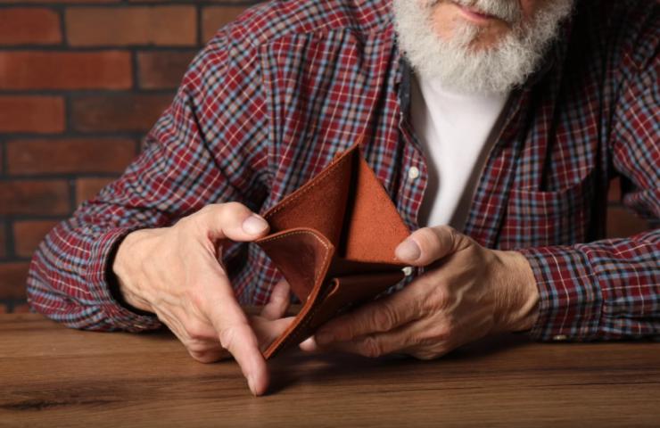 uomo con in mano un portafoglio vuoto