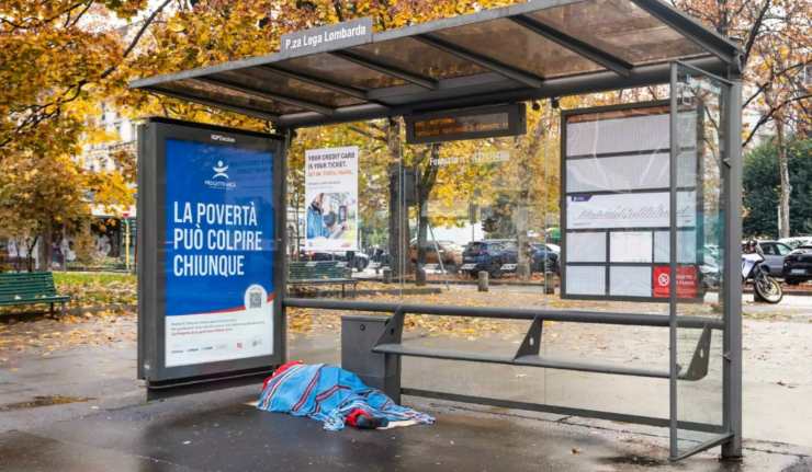 un'installazione di babbo natale che dorme sotto una pensilina a Milano