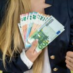 donna con in mano tante banconote di euro