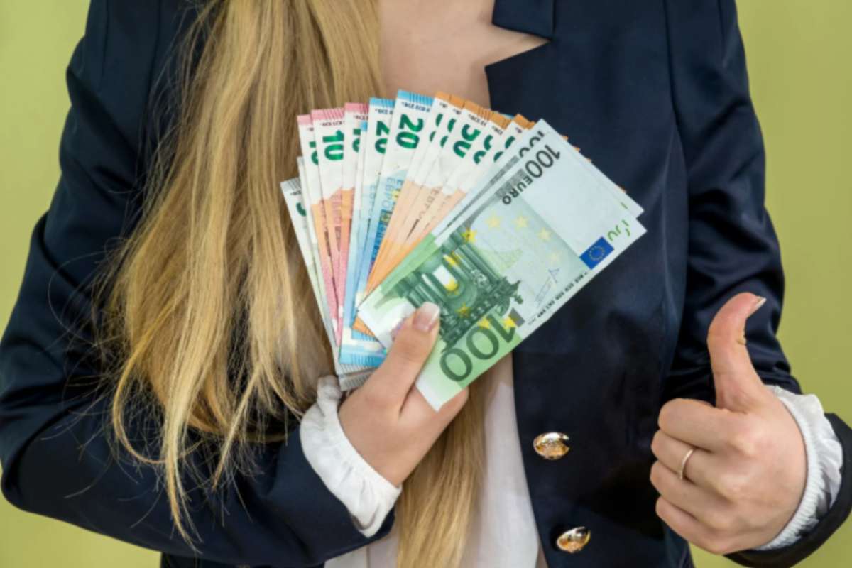 donna con in mano tante banconote di euro