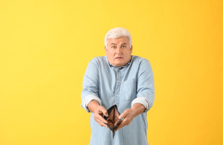 uomo anziano che tiene in mano un portafoglio vuoto