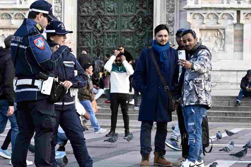 Due persone che si fanno un selfie col cellullare davanti alla polizia