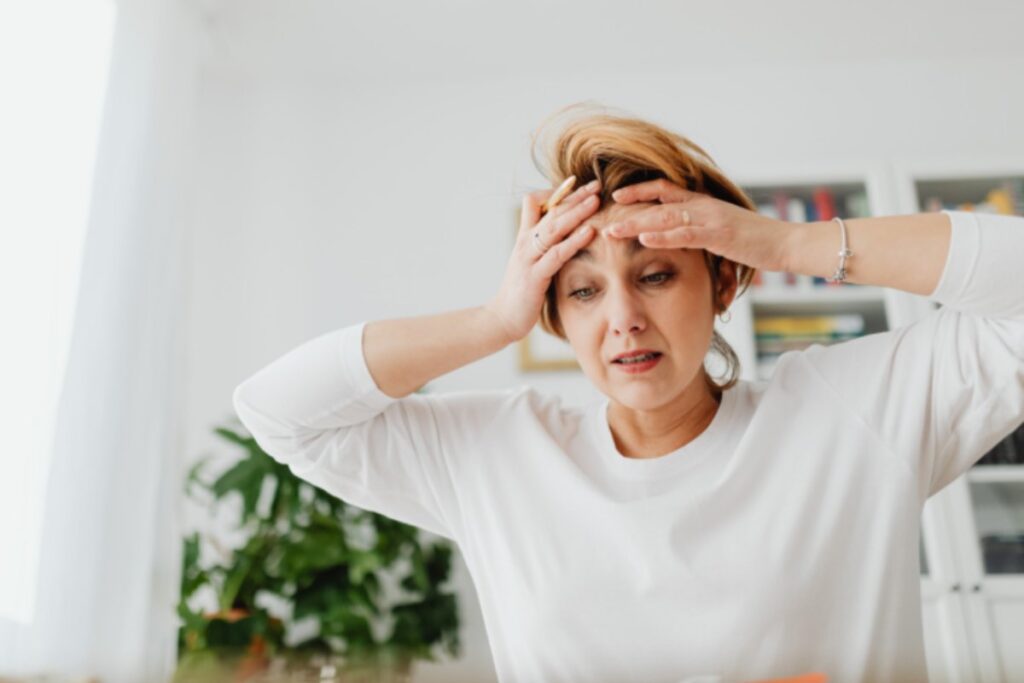 donna preoccupata con le mani sulla fronte