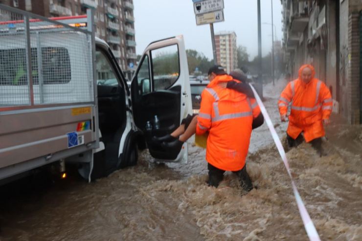 Alcuni operai mentre lavorano per recuperare l'acqua sulle strade