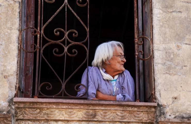 donna anziana sorridente affacciata dalla finestra