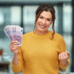 donna che sorride con in mano tante banconote da 500 euro